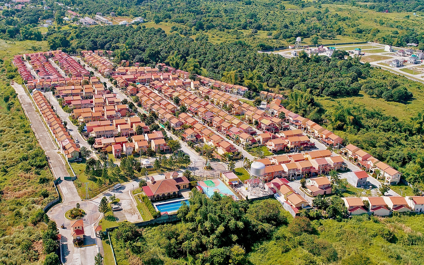 Inside Camella Bataan community with gate, clubhouse, swimming pool, basketball court, and greeneries