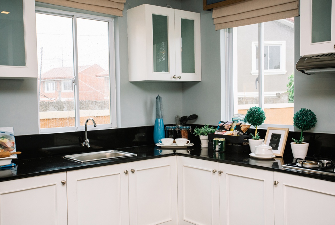 Ella home kitchen area with cabinets