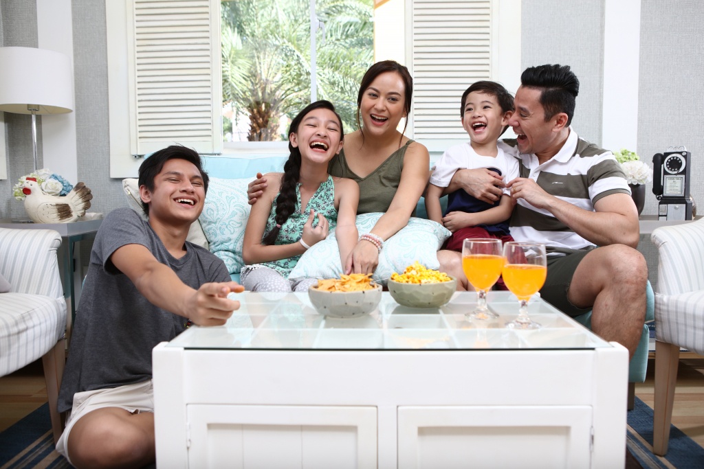 A family laughing and bonding together with food in their own house and lot unit
