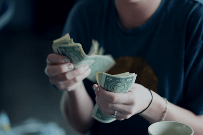 Woman counting money bills with two hands