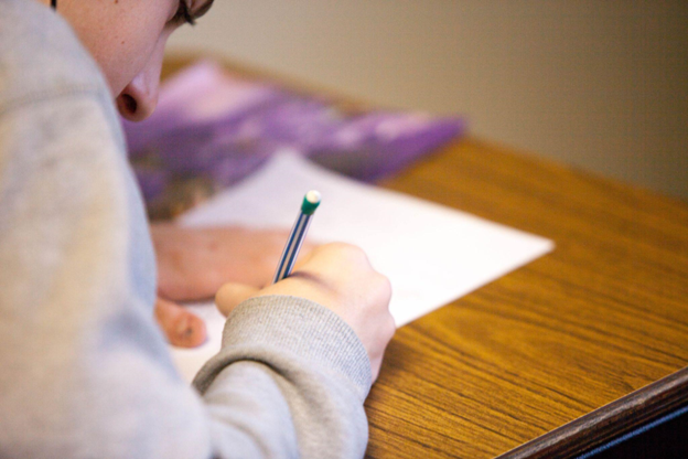 Student writing on a notebook Photo by Ben Mullins on Unsplash