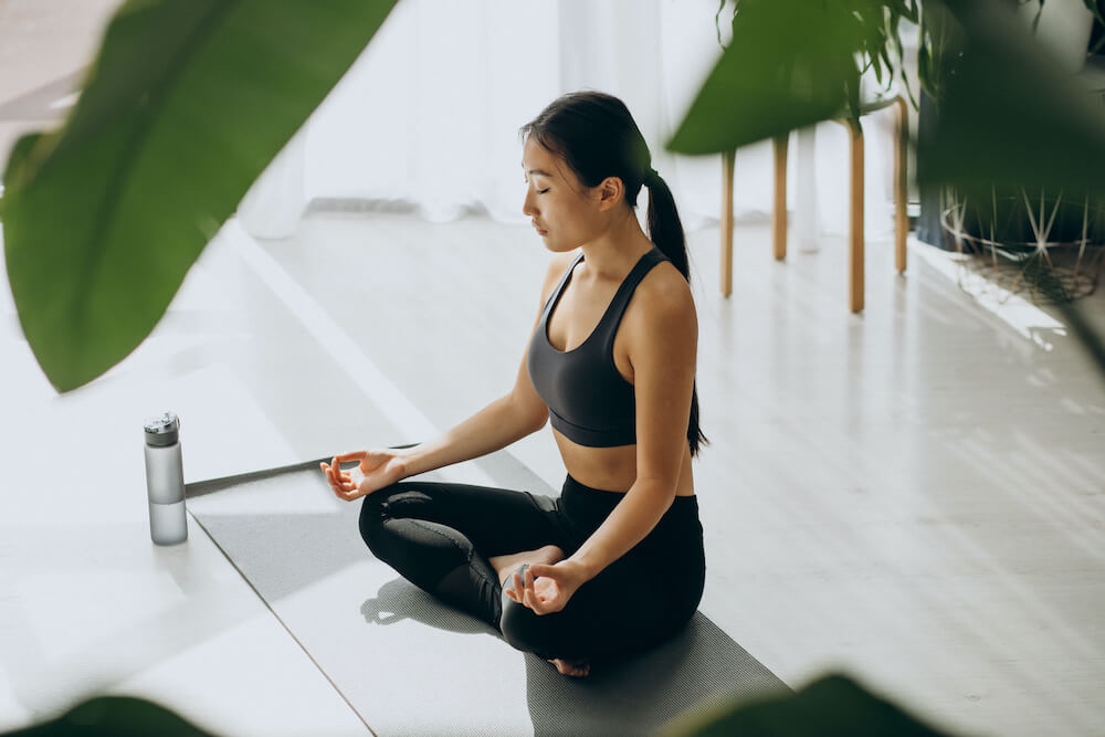 woman-practicing-yoga-mat-home