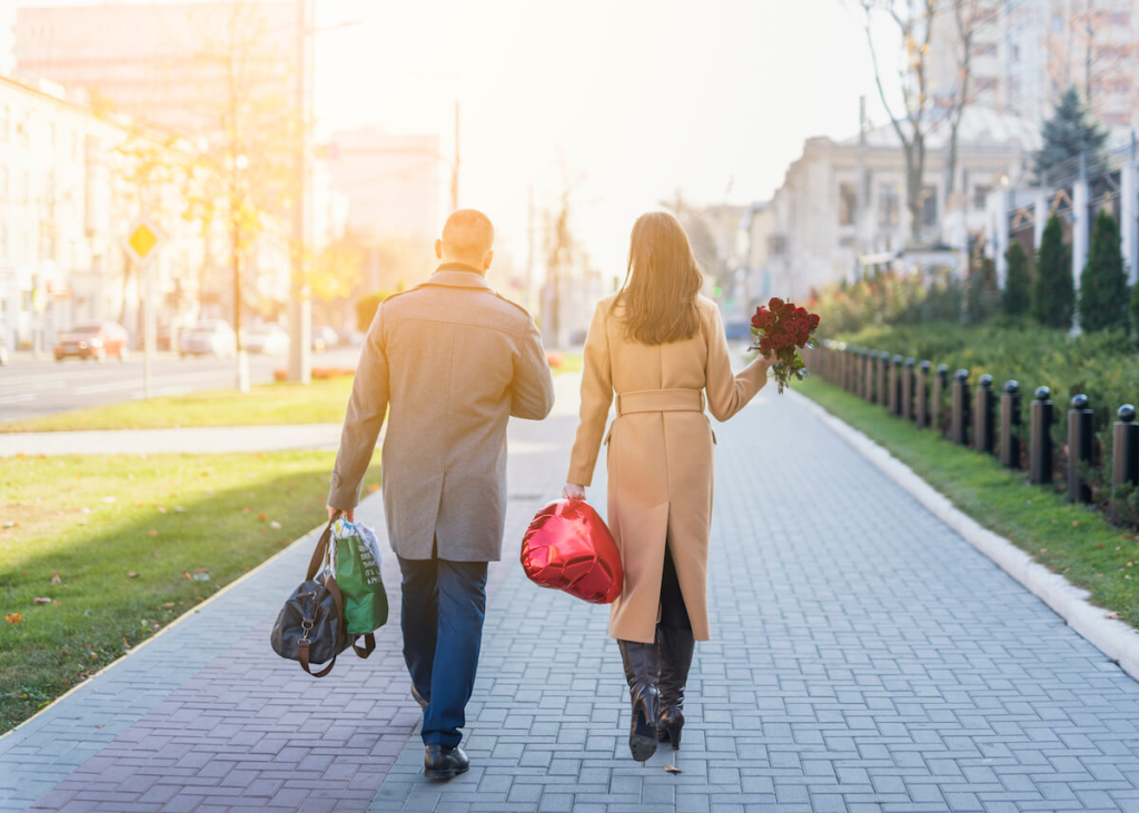 man-woman-with-bags-flowers-going-street(1)