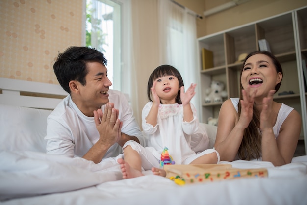 Camella House and lot for growing families l Happy child with parents playing in the bed at home