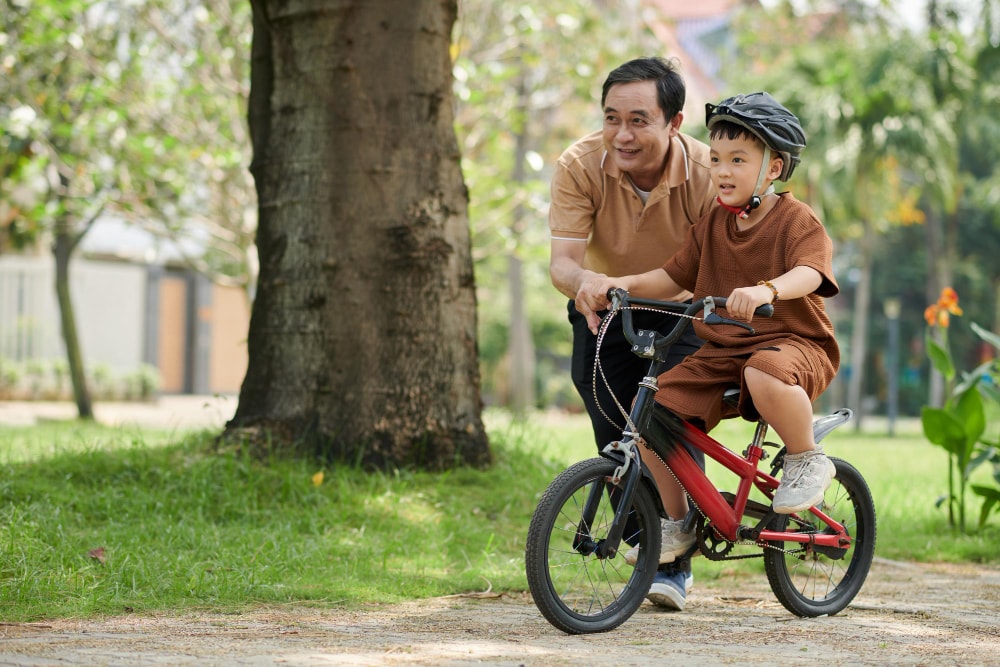 Dad teaching his son to ride a bike