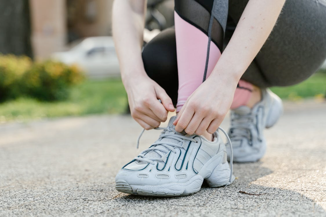 Photo by MART PRODUCTION: https://www.pexels.com/photo/a-person-tying-her-shoelace-7880010/