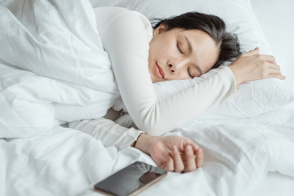 Using exercise for better sleep quality l Photo by Ketut Subiyanto: https://www.pexels.com/photo/woman-sleeping-in-bed-near-smartphone-4473864/
