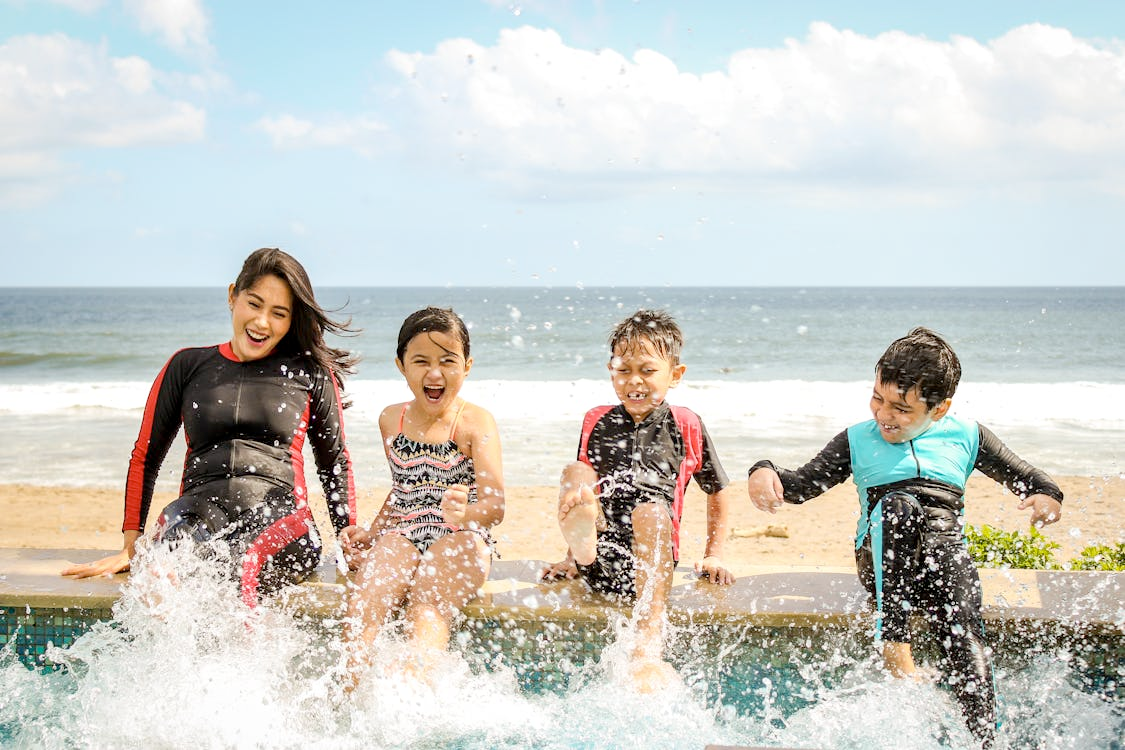 Identifying the role of Ai in family communication system l Photo by Yulianto Poitier: https://www.pexels.com/photo/woman-and-three-children-playing-water-1231365/