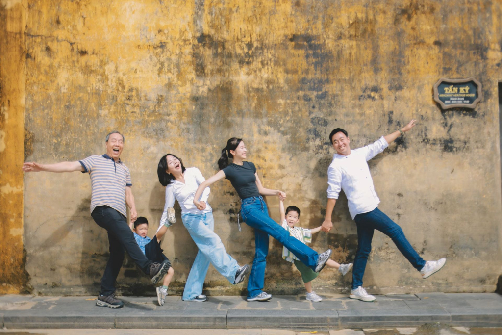 Planning for a multigenerational family getaway l Family posing playfully against a textured wall.