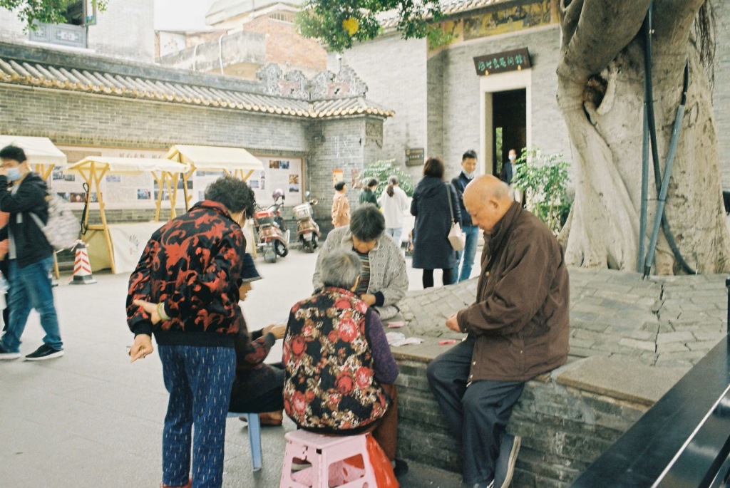 a group of people sitting on a bench in a courtyard